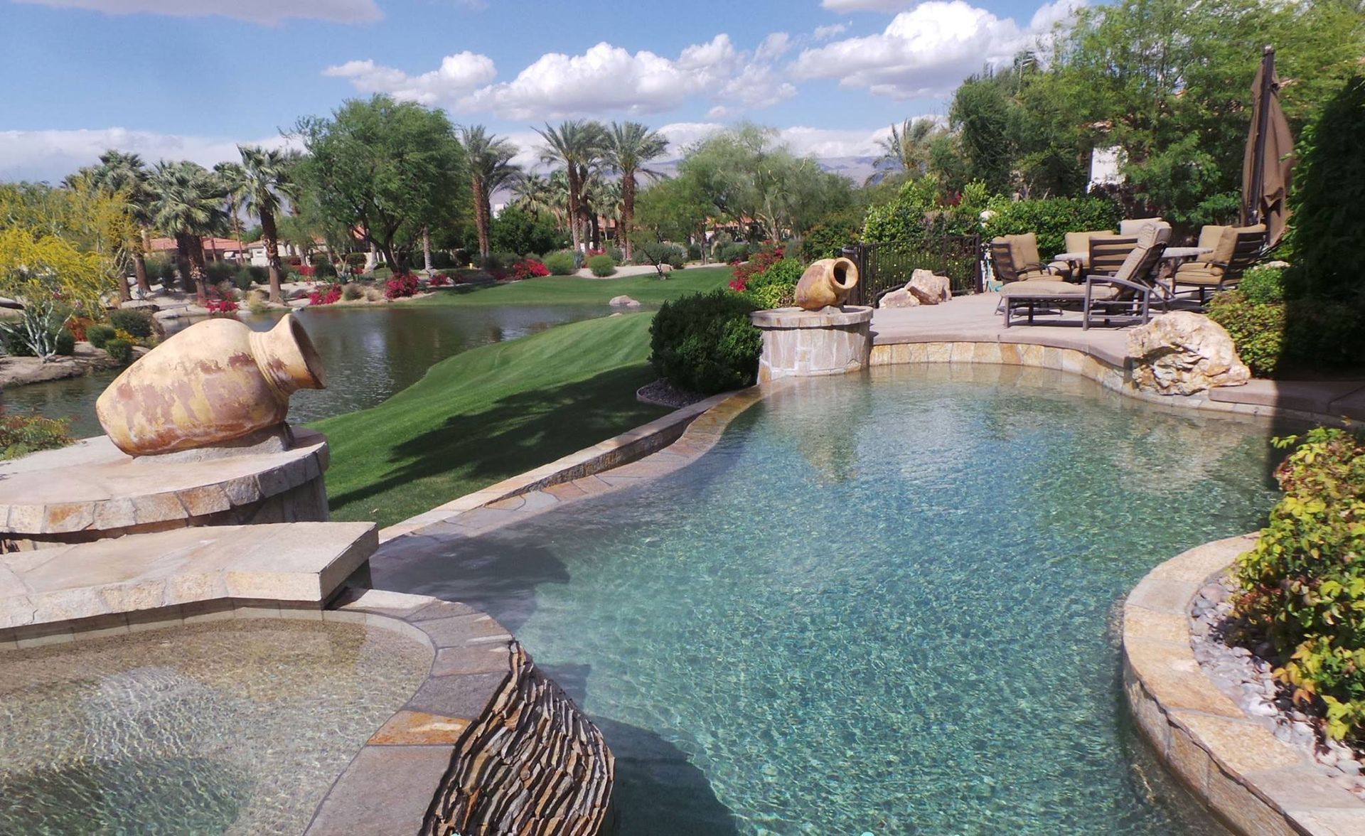 A large swimming pool with a hot tub in the middle of it