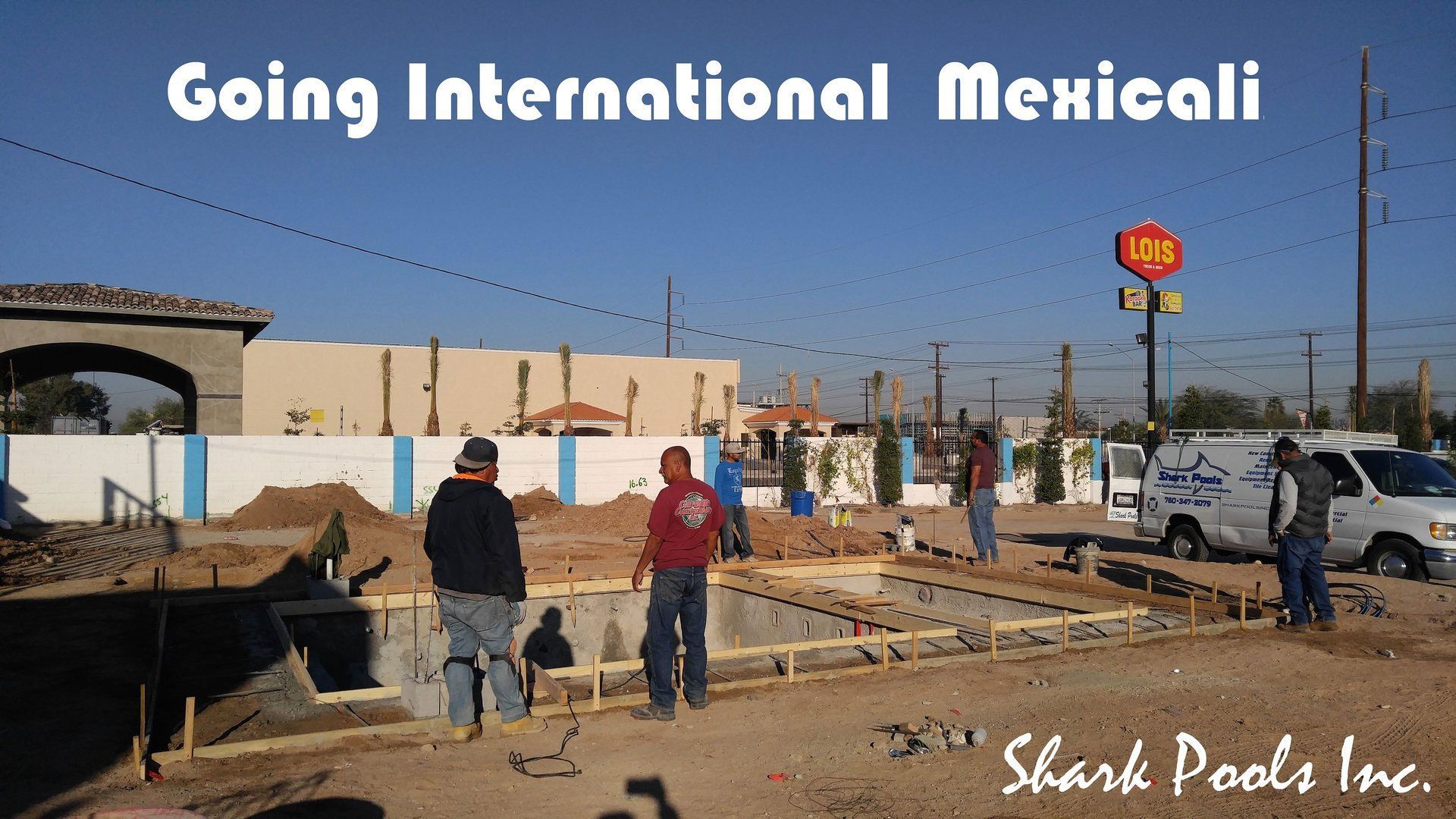 A group of construction workers are standing in front of a sign that says going international mexicali