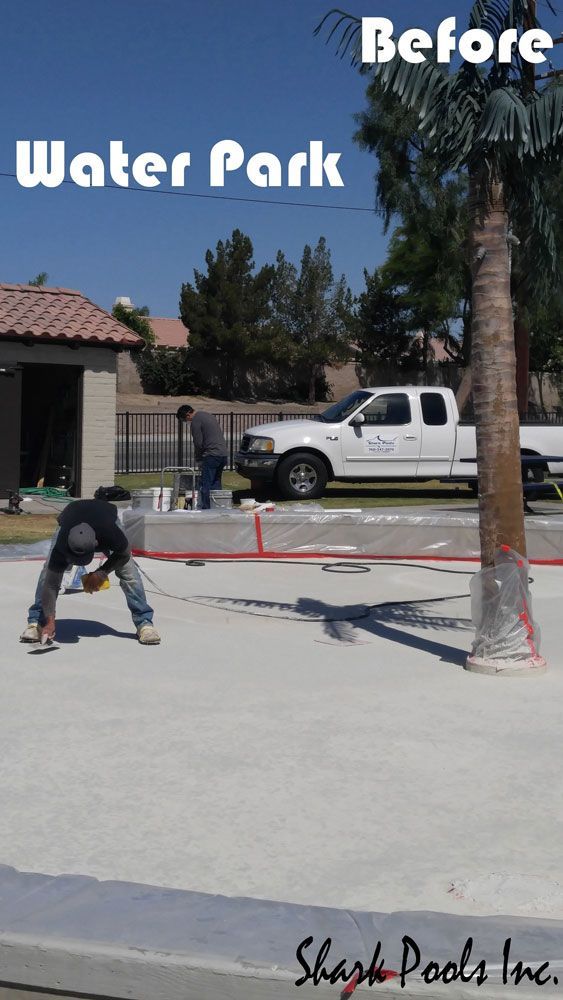 A white truck is parked in front of a water park