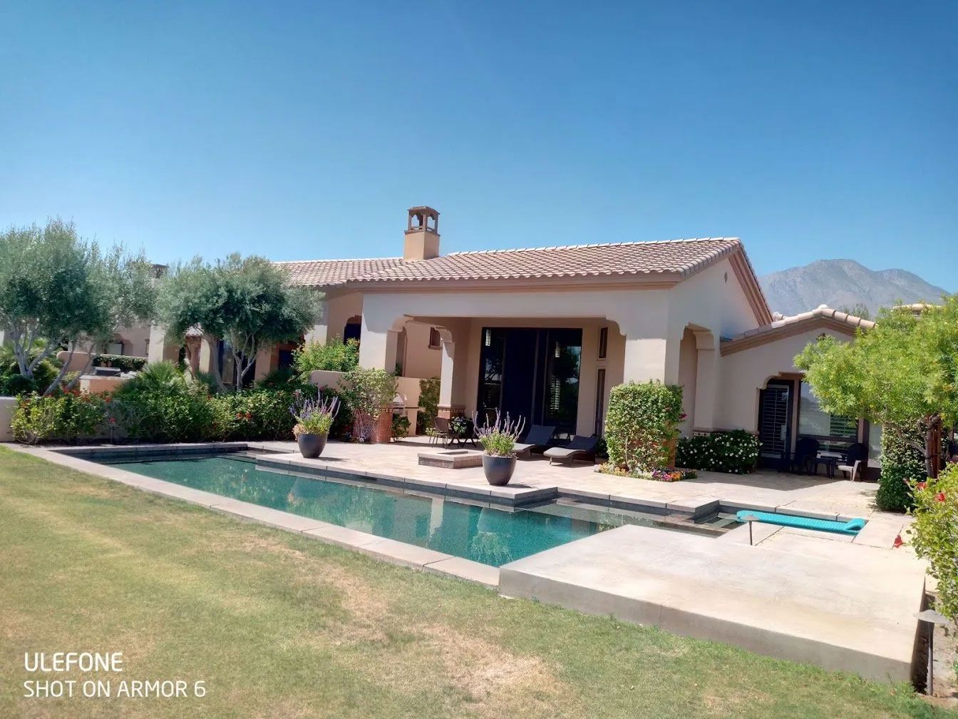 A house with a large swimming pool in front of it
