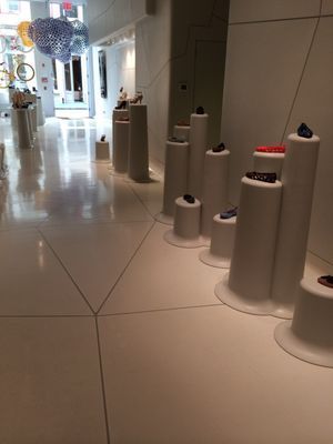 White shoe store interior with display pedestals, polished floor, and merchandise.