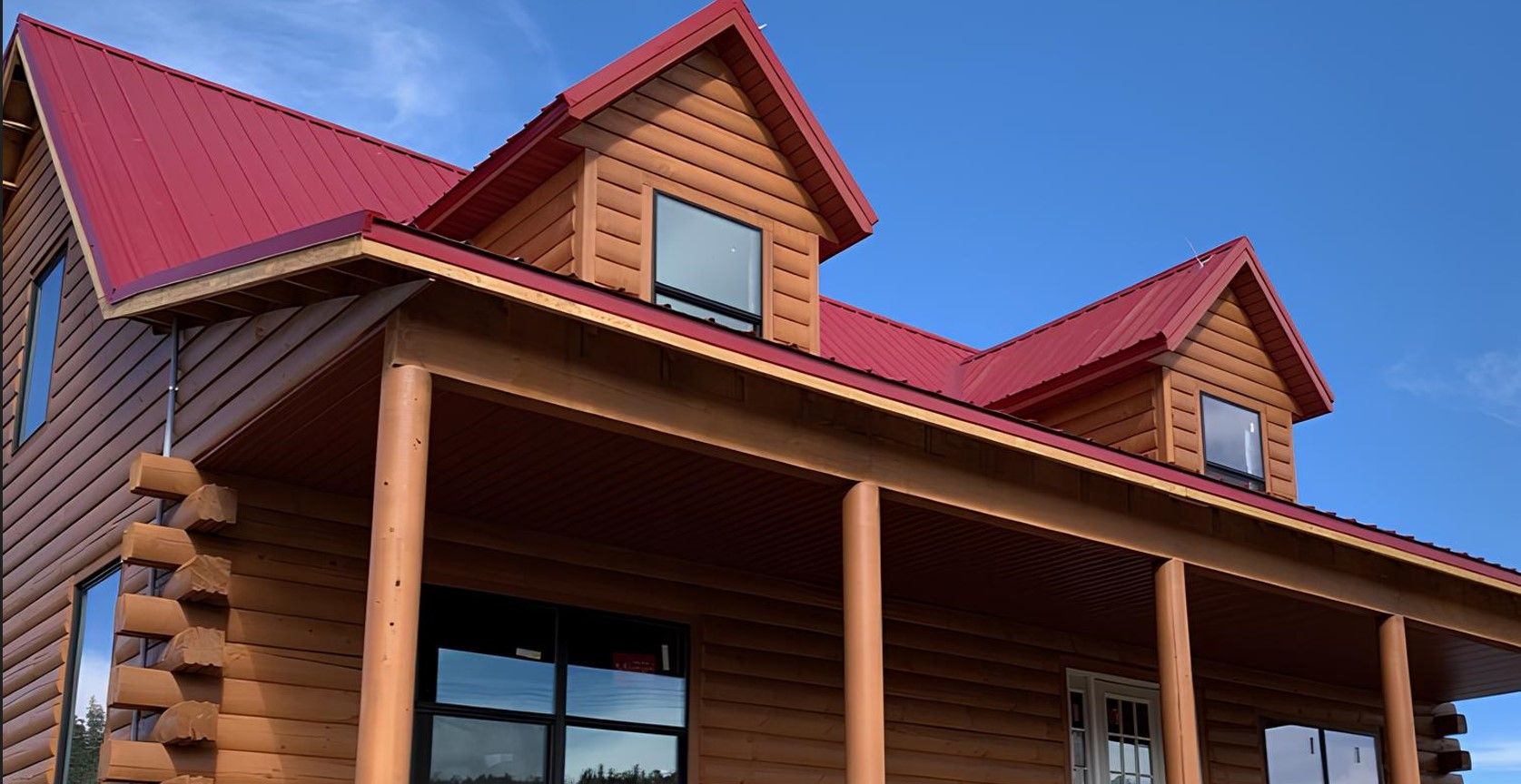 A log cabin with a red roof and a porch