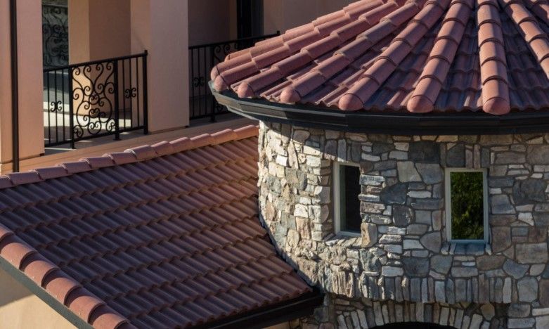 A stone building with a red tiled roof