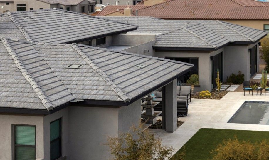 An aerial view of a house with a tiled roof and a pool.