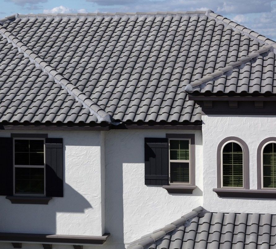 A white house with a tiled roof and arched windows