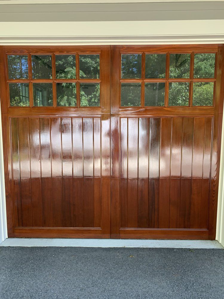 Wooden garage door with upper windows and a gray carpeted floor in front