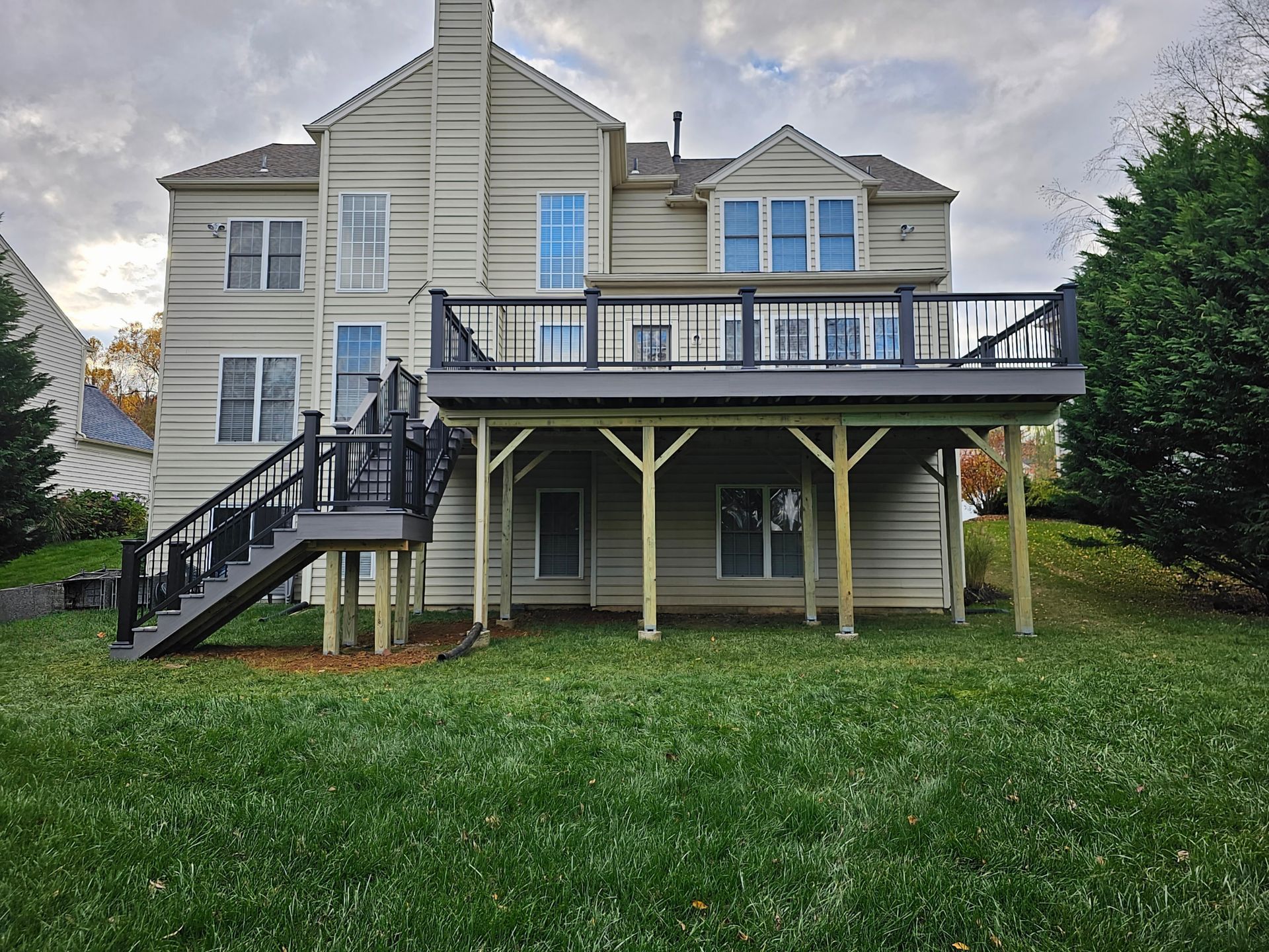 The back of a house with a large deck and stairs