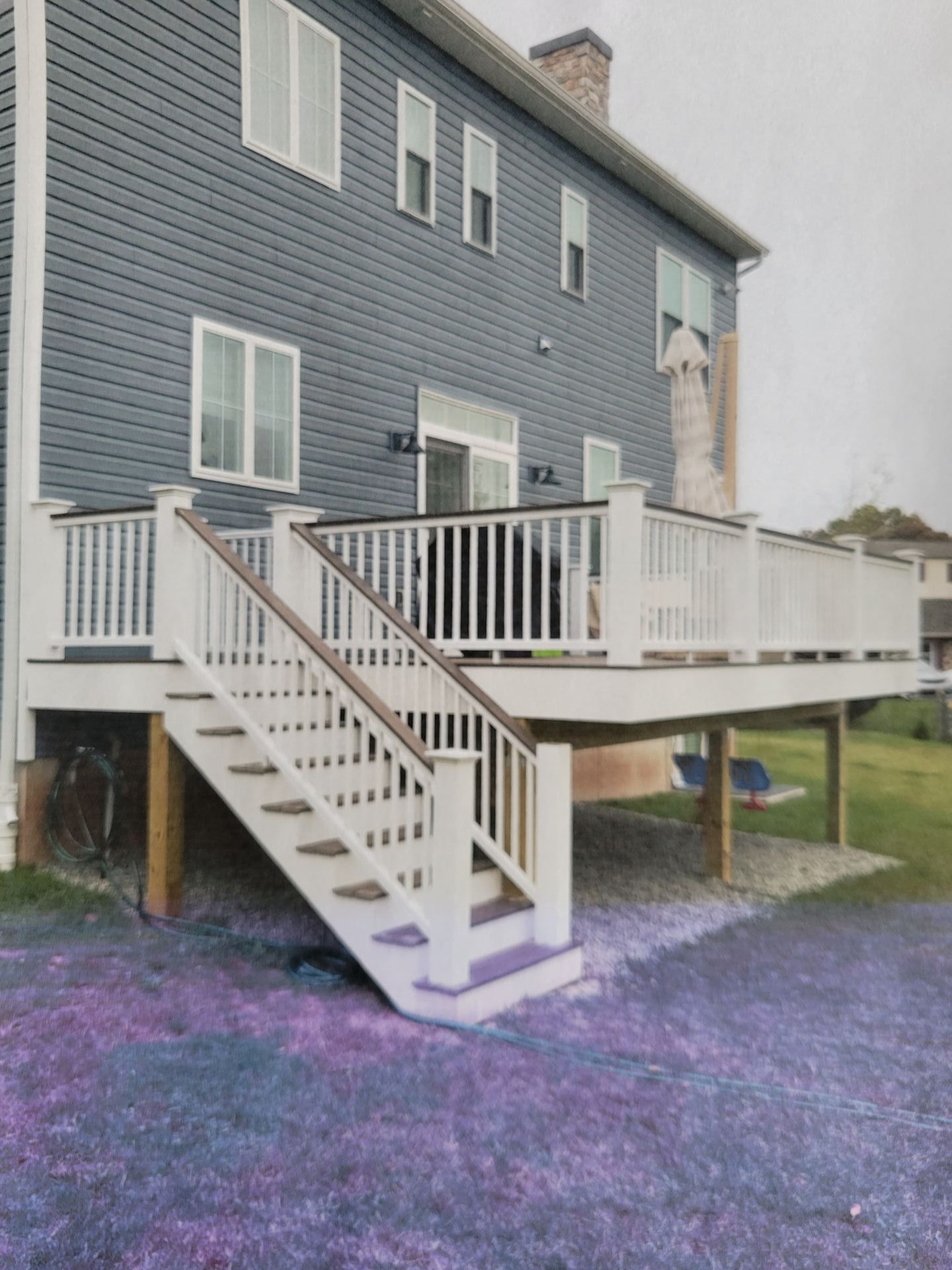A house with a deck and stairs in front of it