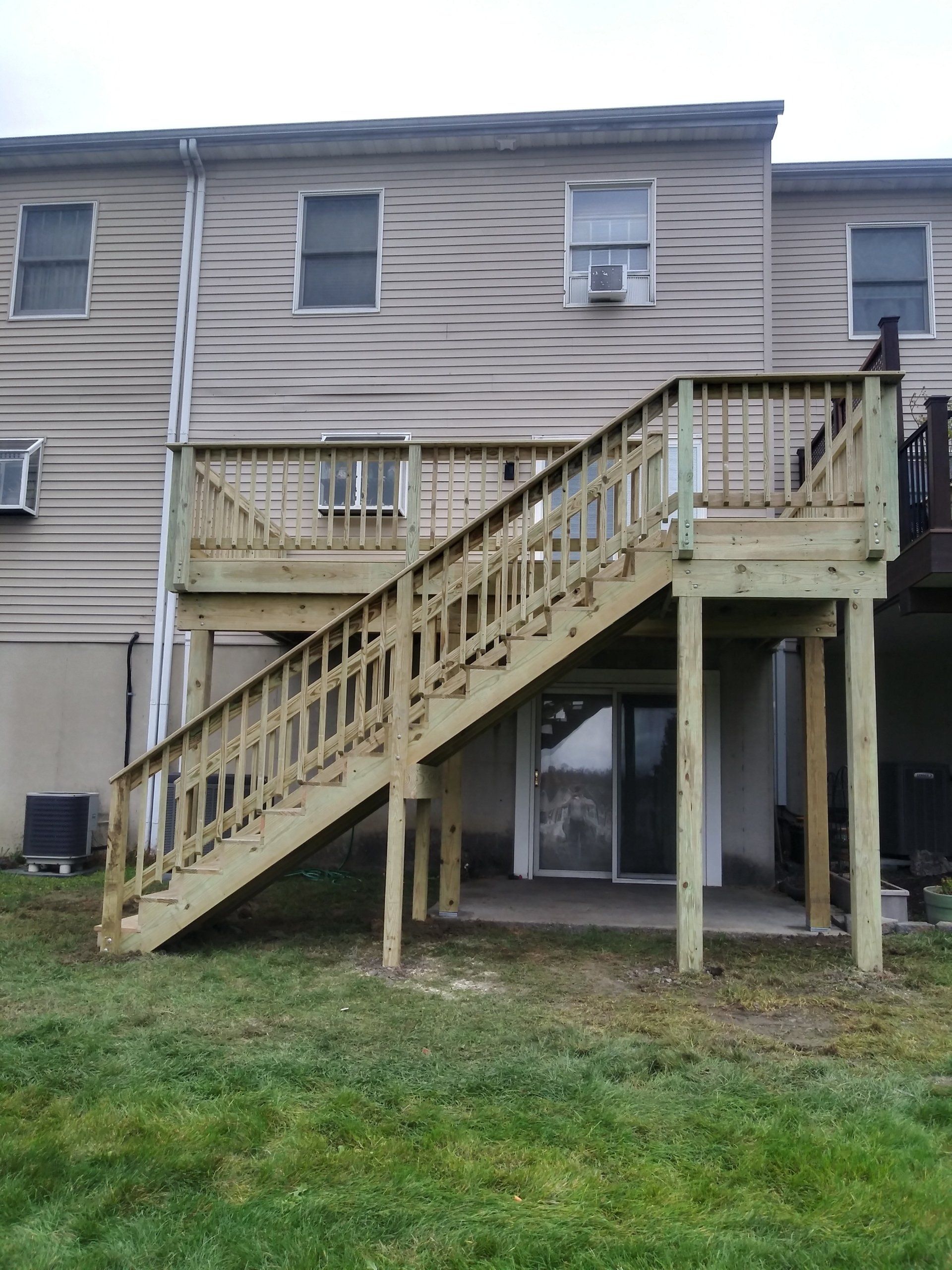 The back of a house with a wooden deck and stairs