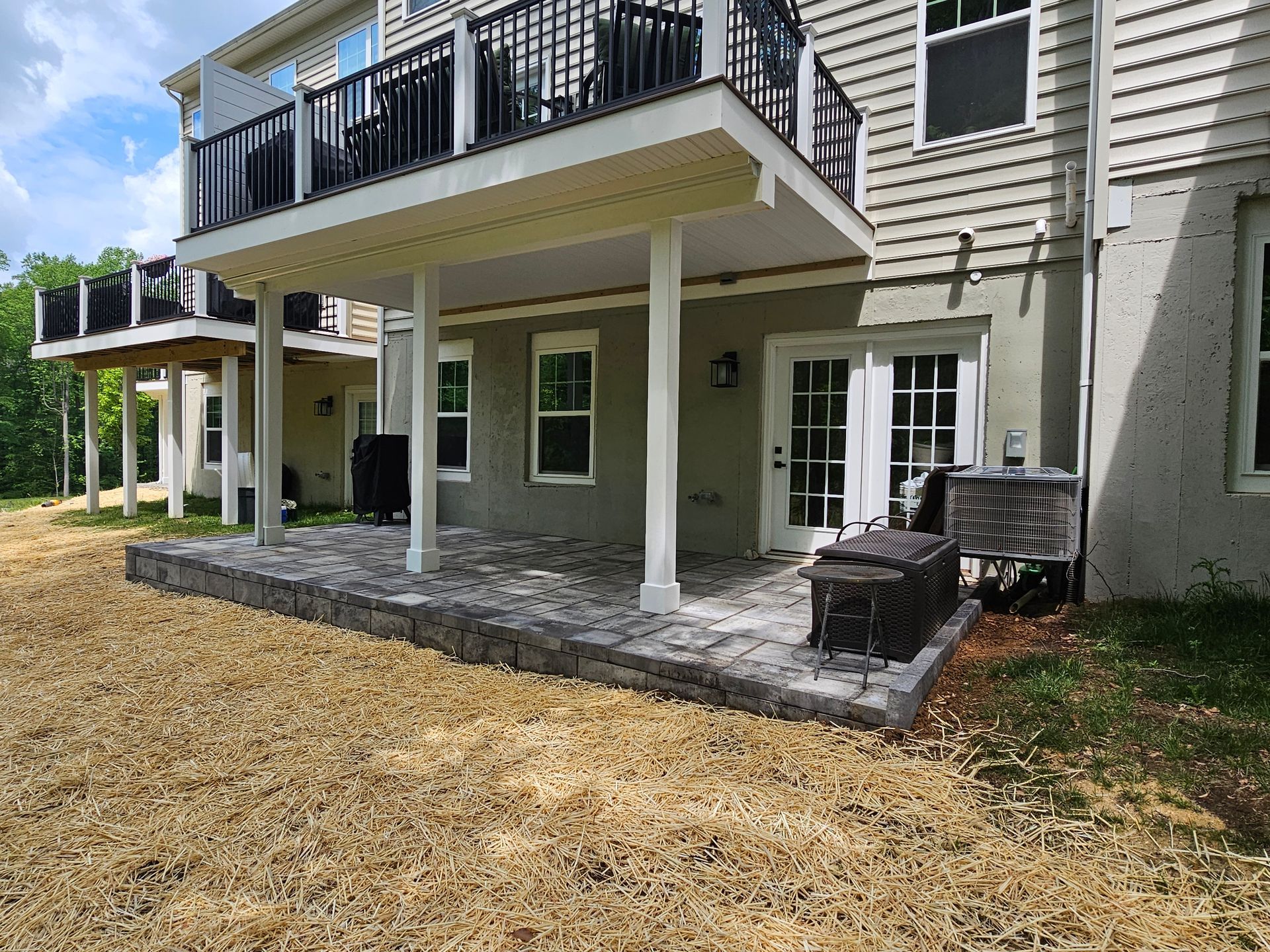 The backyard of a house with a patio and a balcony