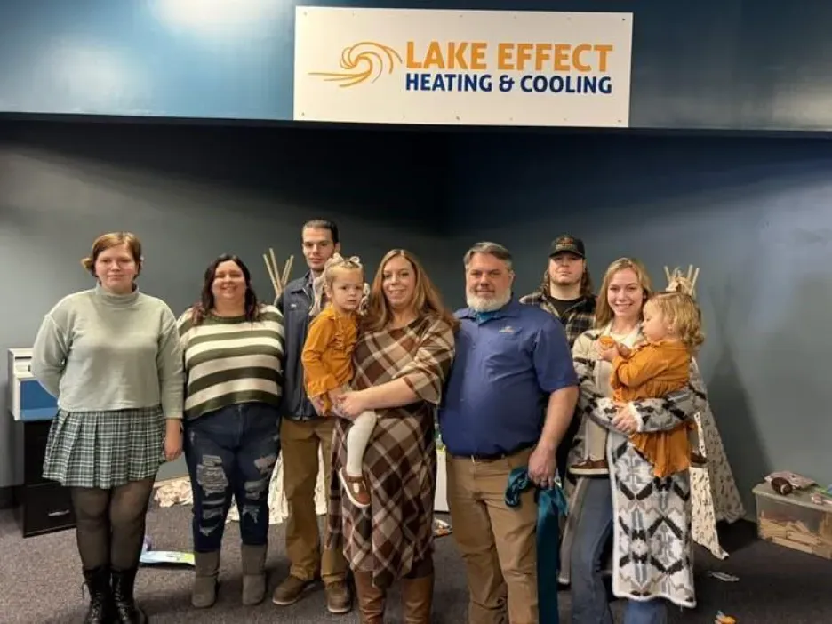 Group of people posing in front of a 