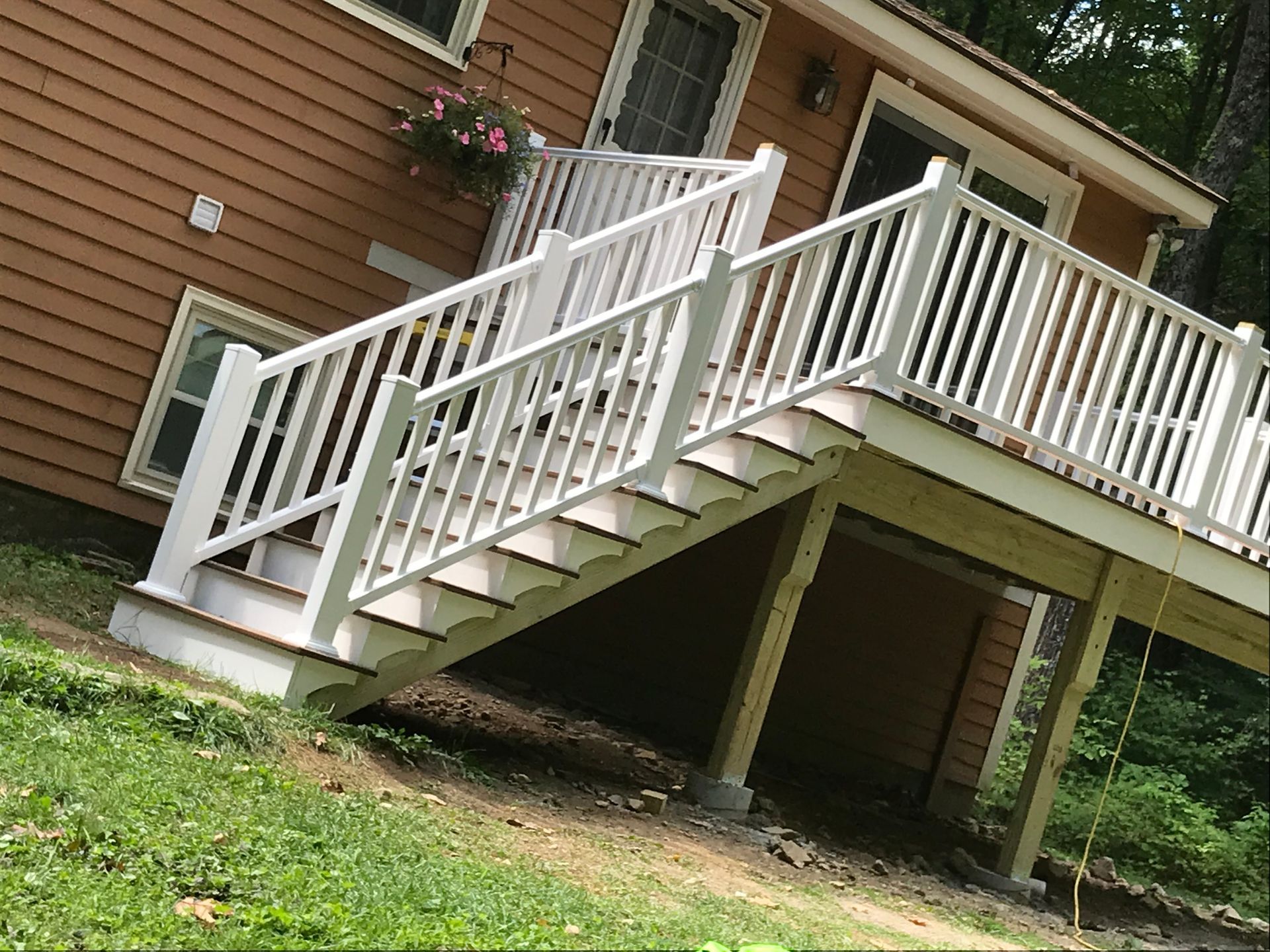 A house with a deck and stairs leading up to it.