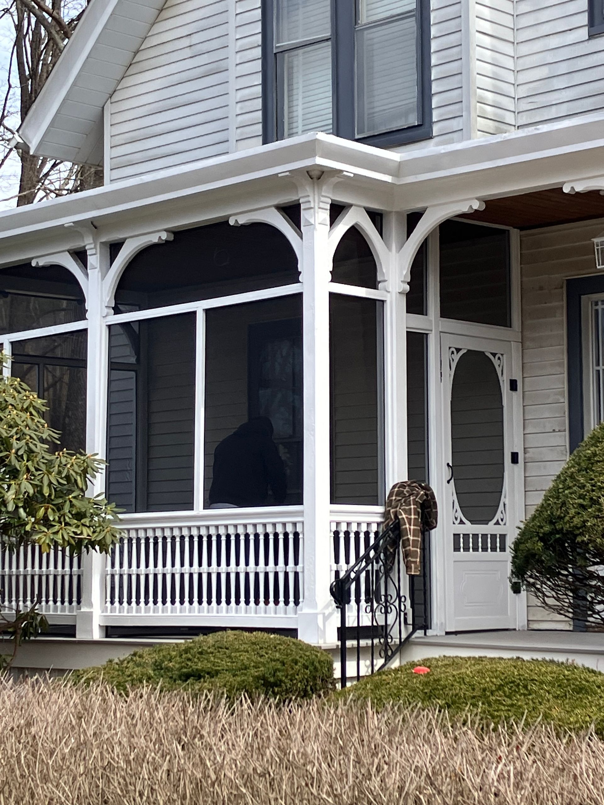 A white house with a screened in porch and stairs