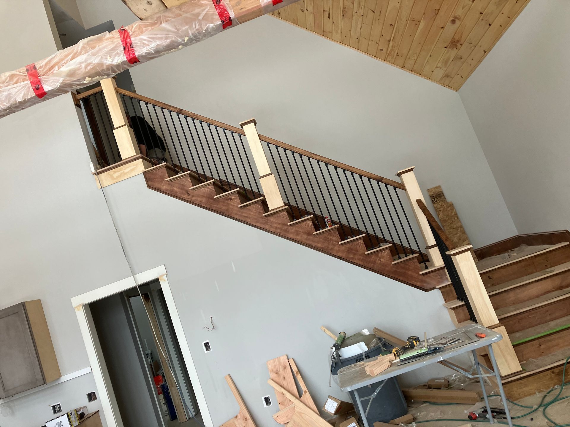 A wooden staircase is being built in a house.