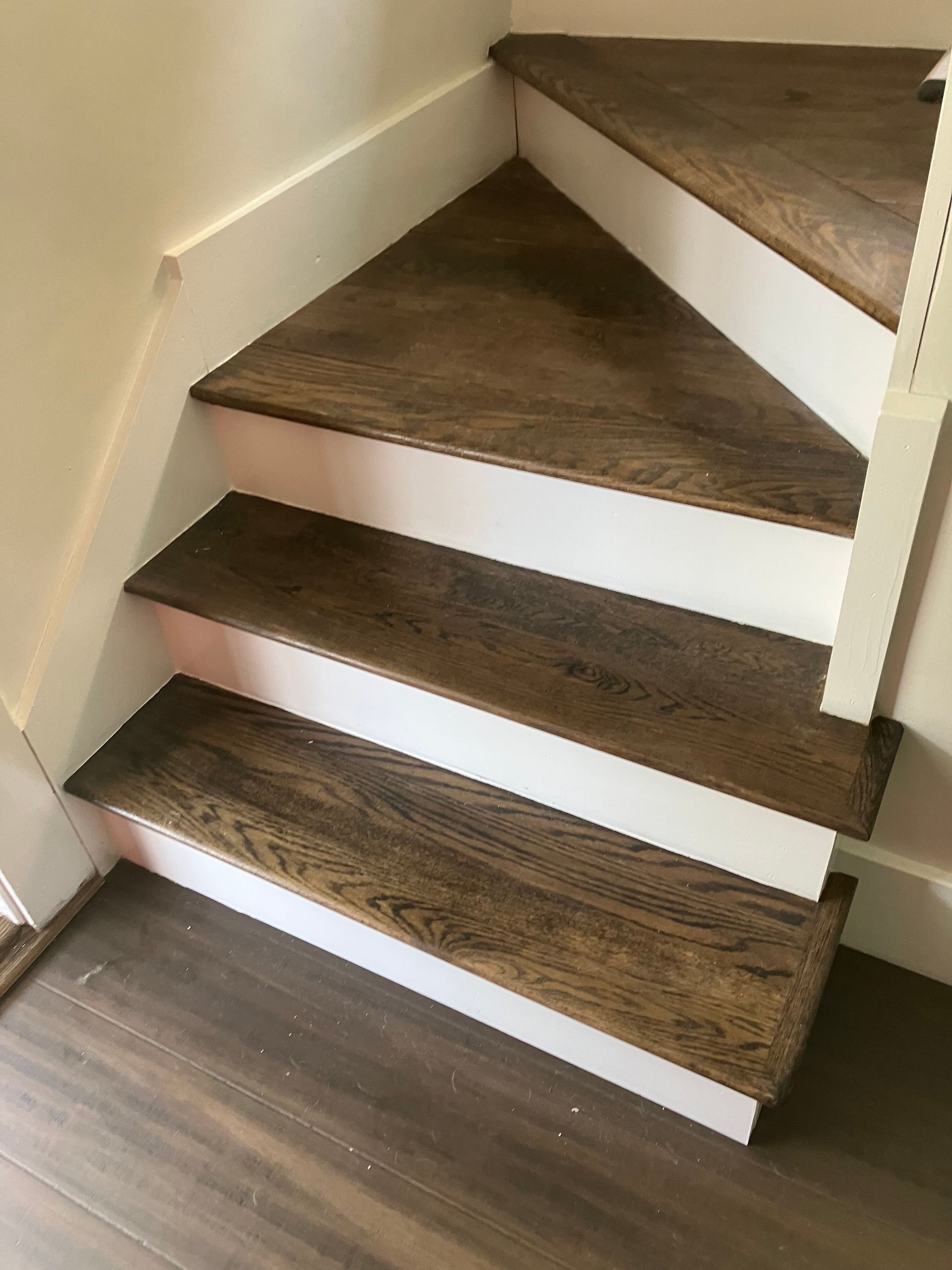 A close up of a wooden staircase with white steps.