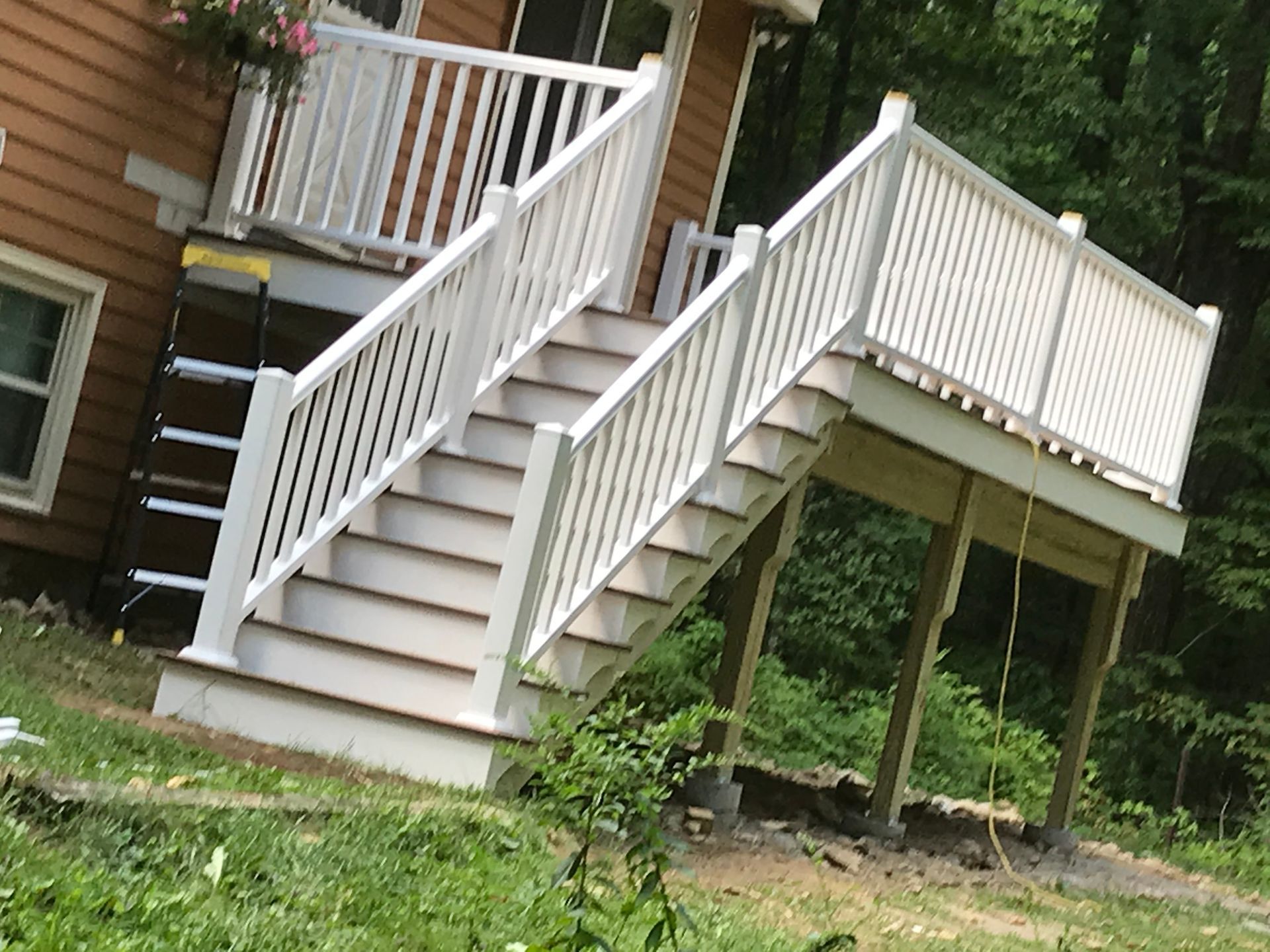 A white deck with stairs leading up to it