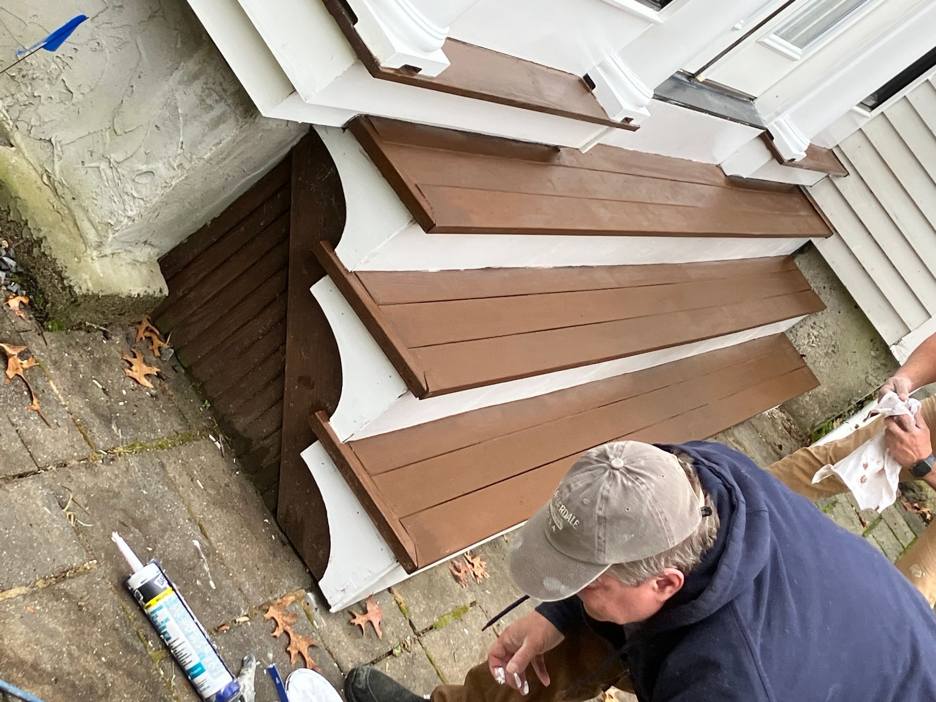 A man is painting the steps of a house.