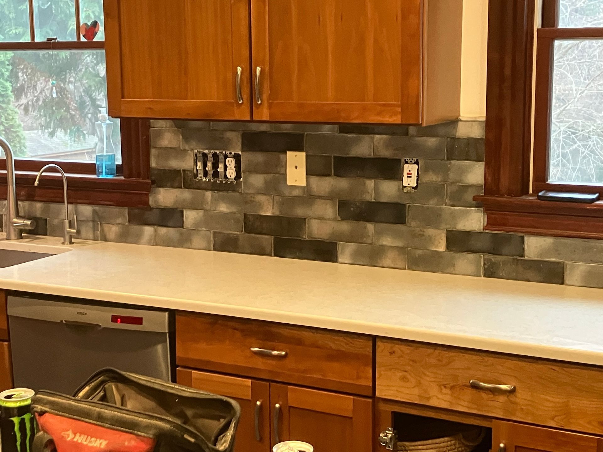 A kitchen with wooden cabinets and a monster energy drink