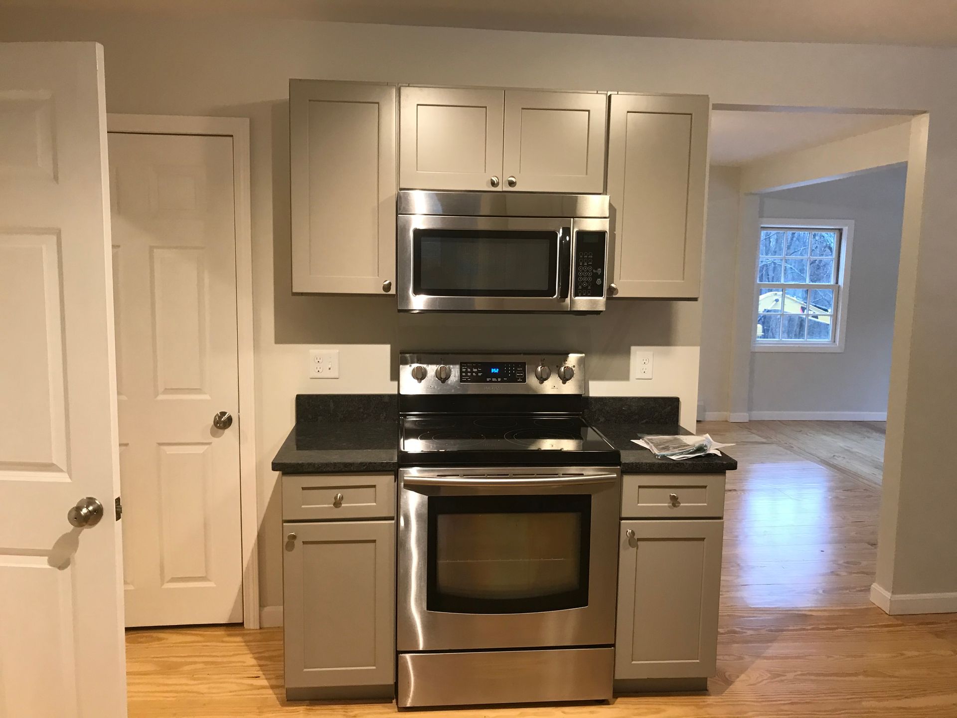 A kitchen with stainless steel appliances and gray cabinets