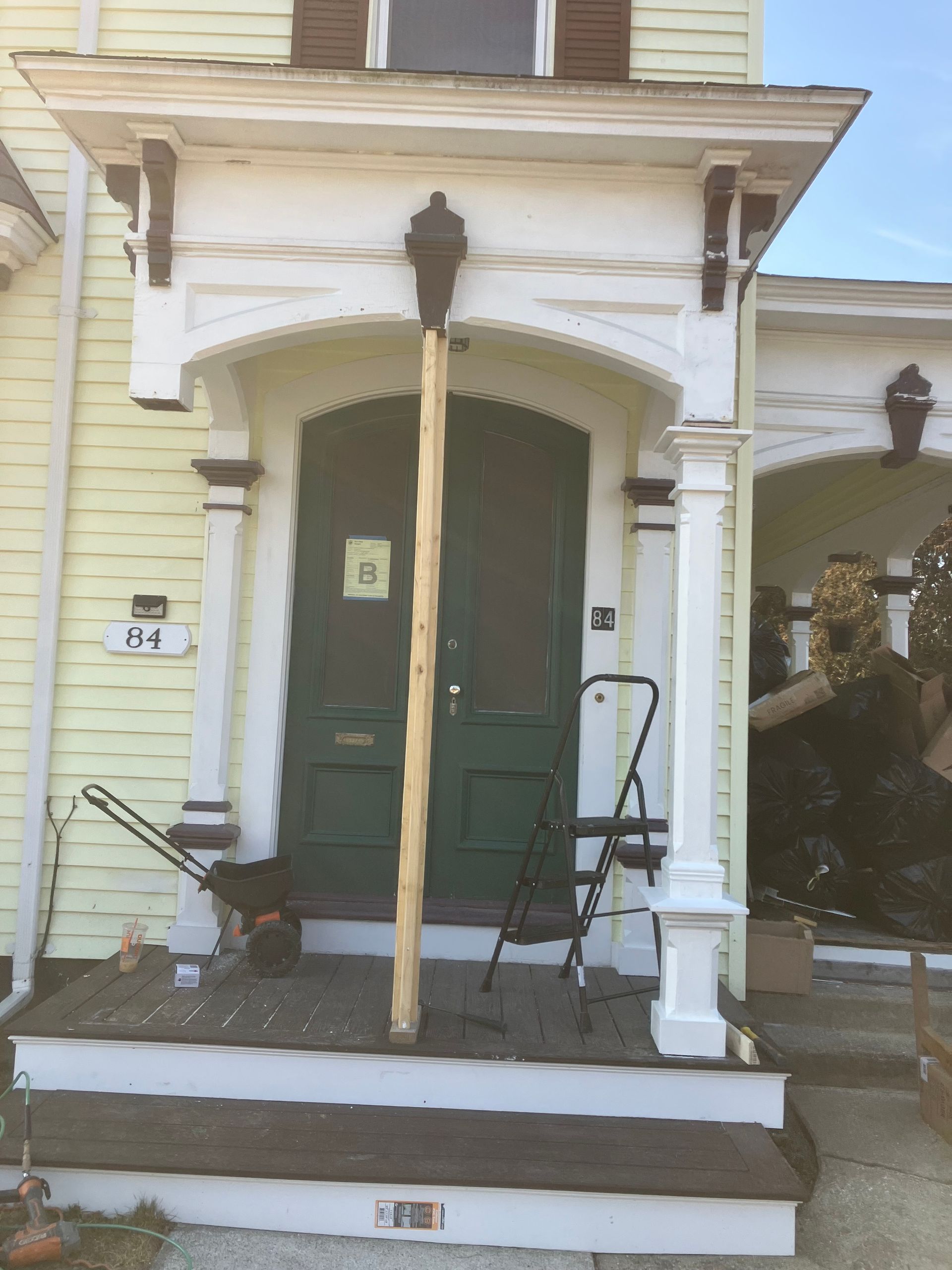 A yellow house with the number 84 on the front door
