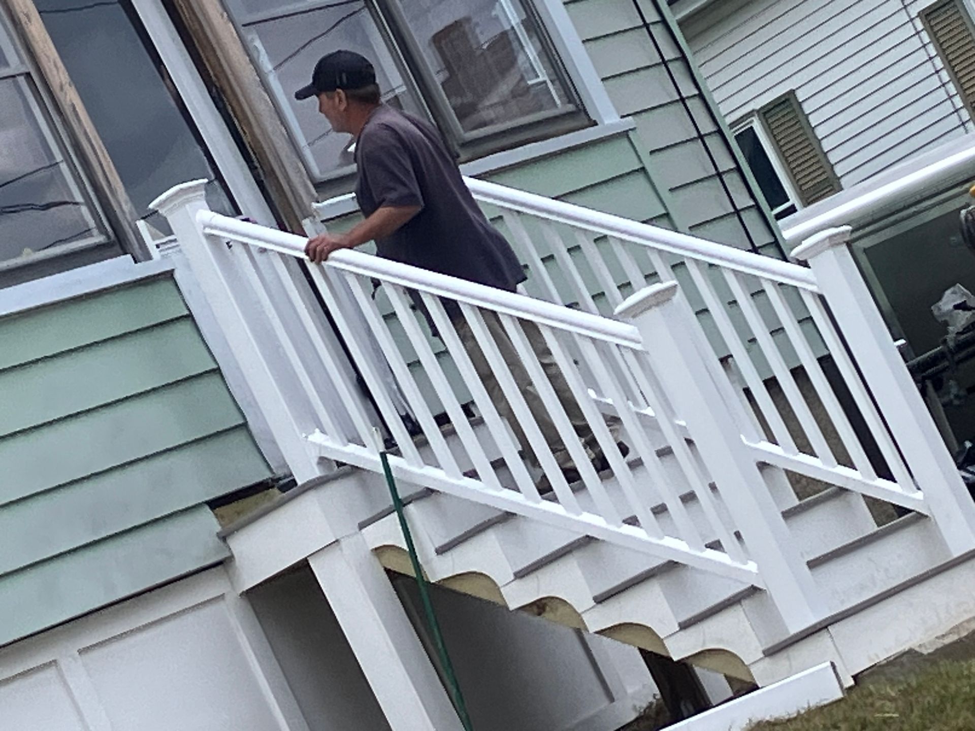 A man is standing on the stairs of a house.