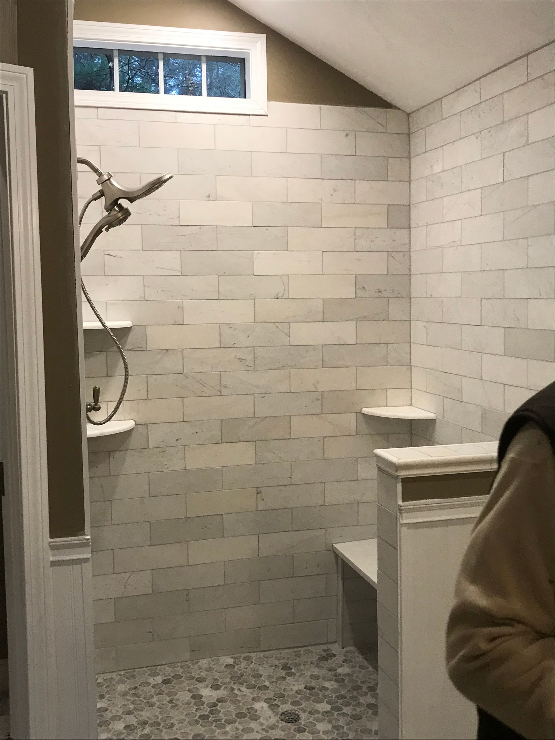 A bathroom with a walk in shower and a window