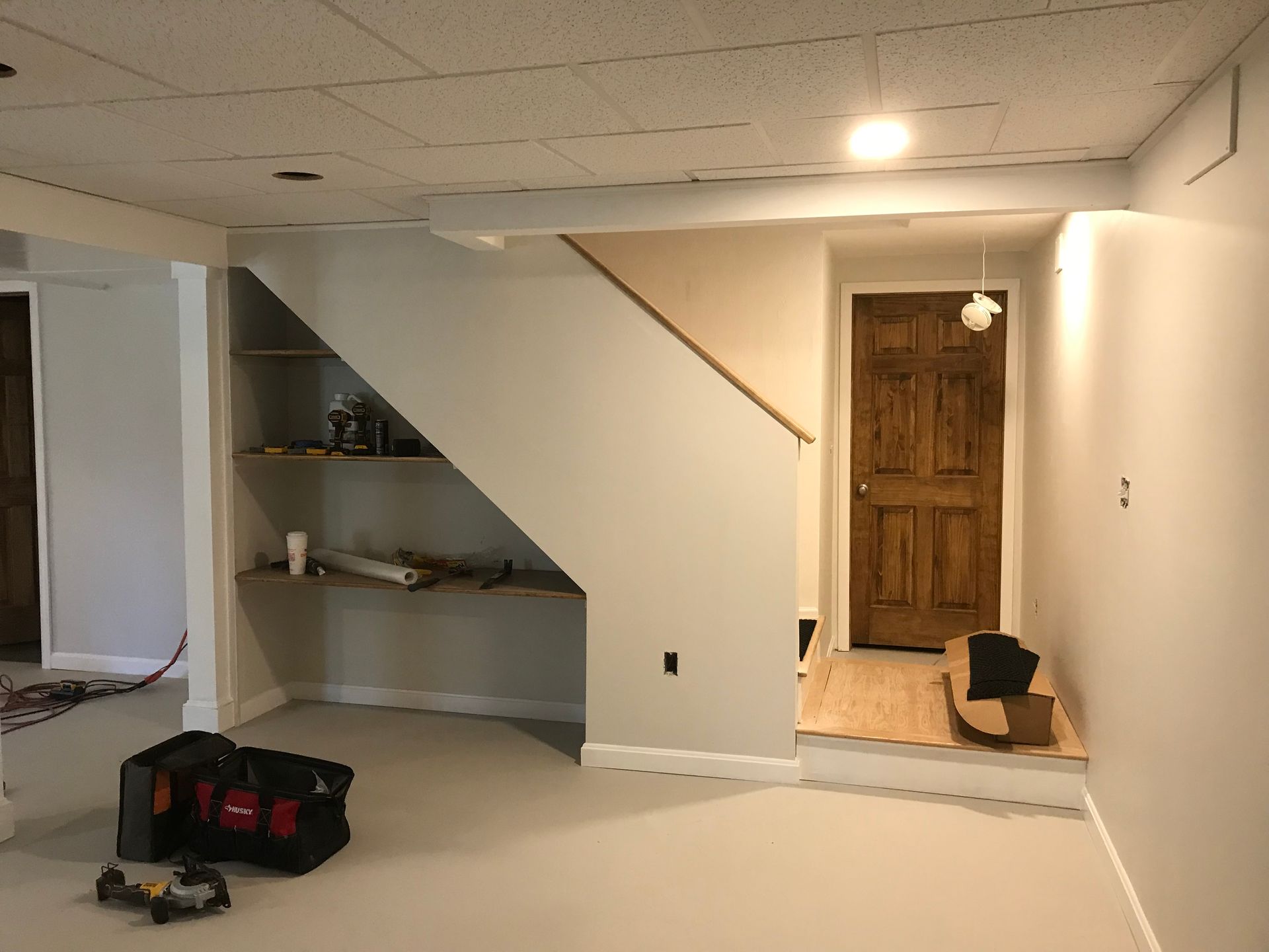 An empty basement with a staircase and a door