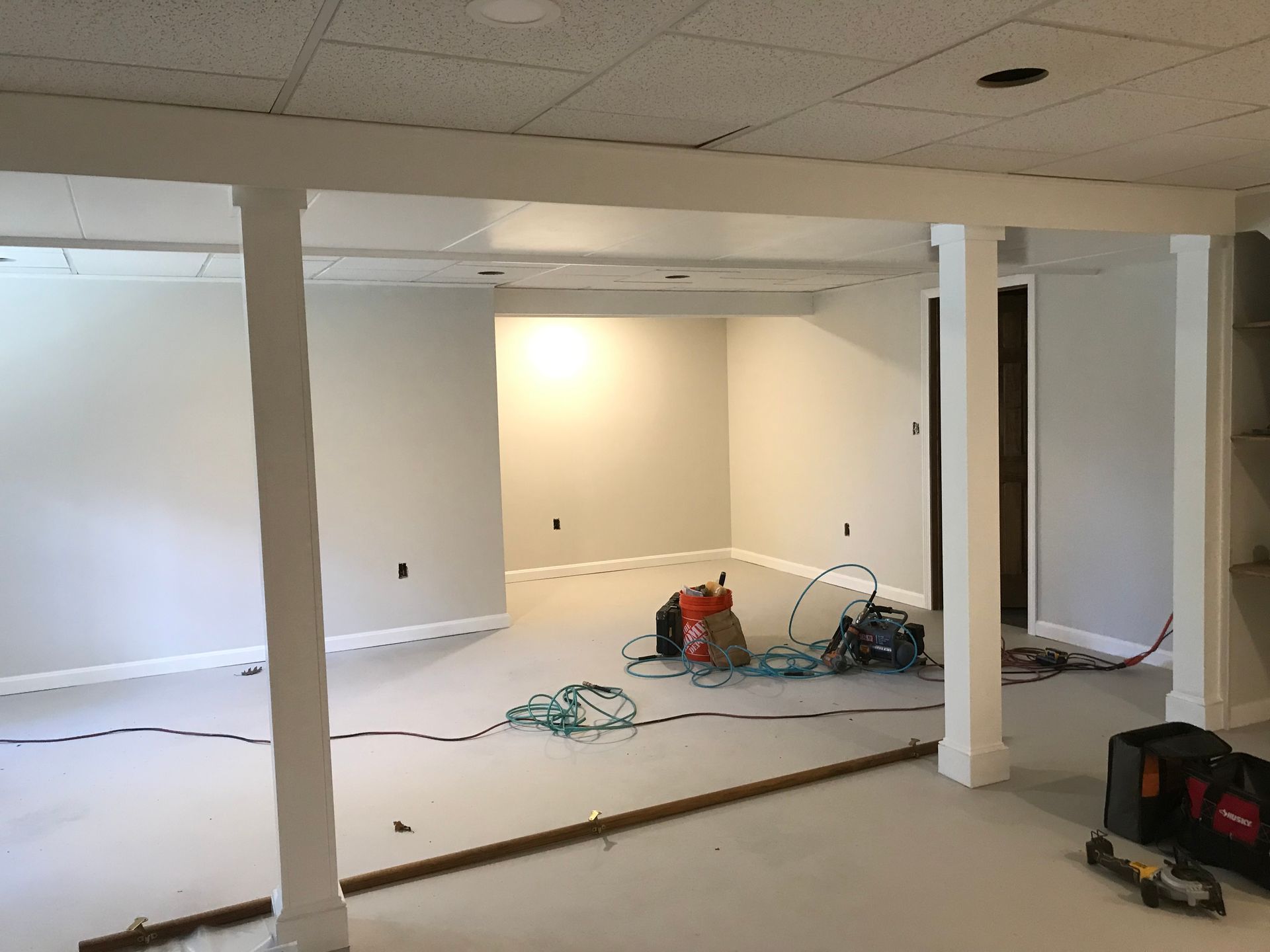 An empty basement with white walls and pillars