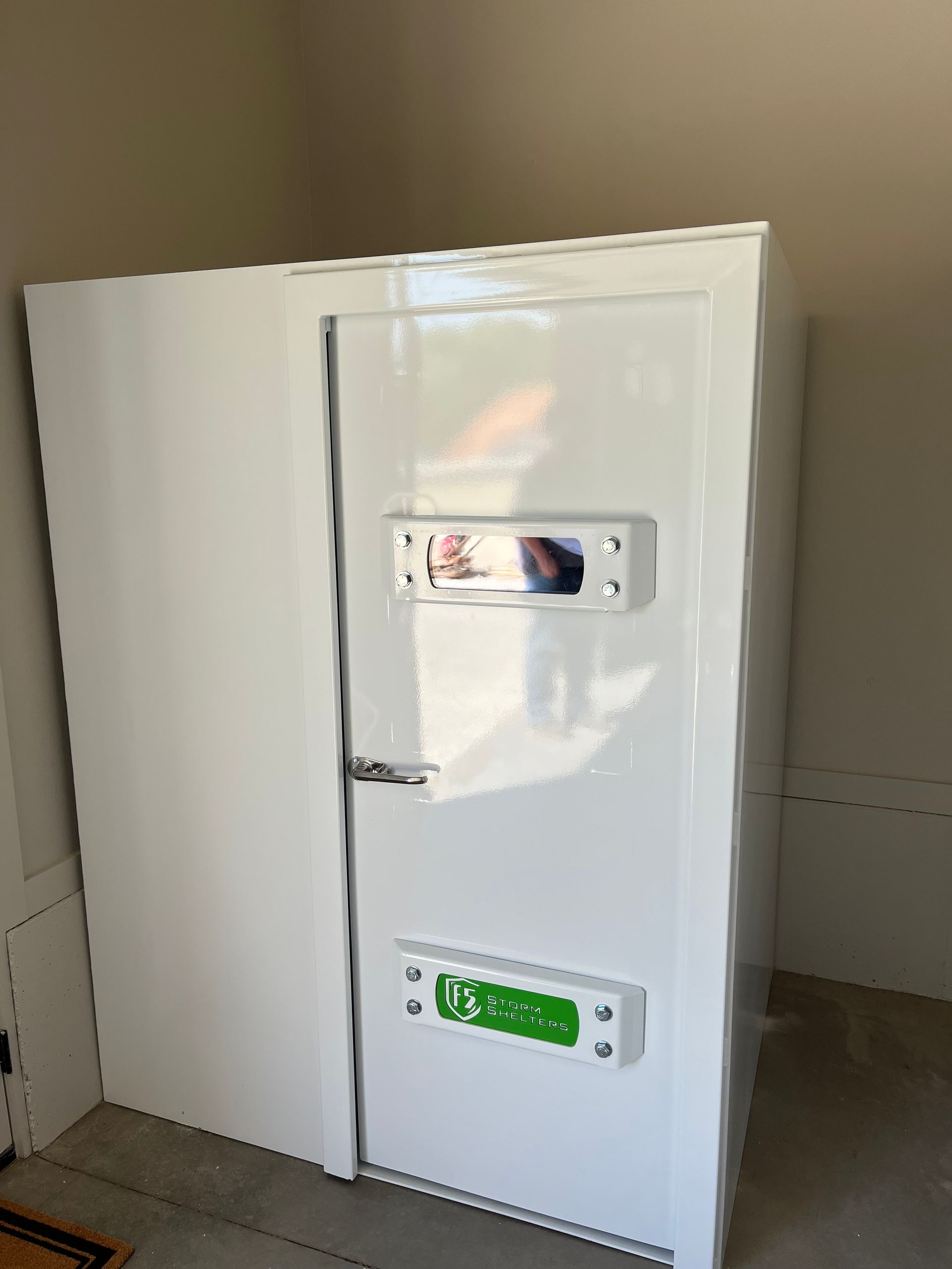 White walk-in cooler or fridge with a partially open door in a plain room