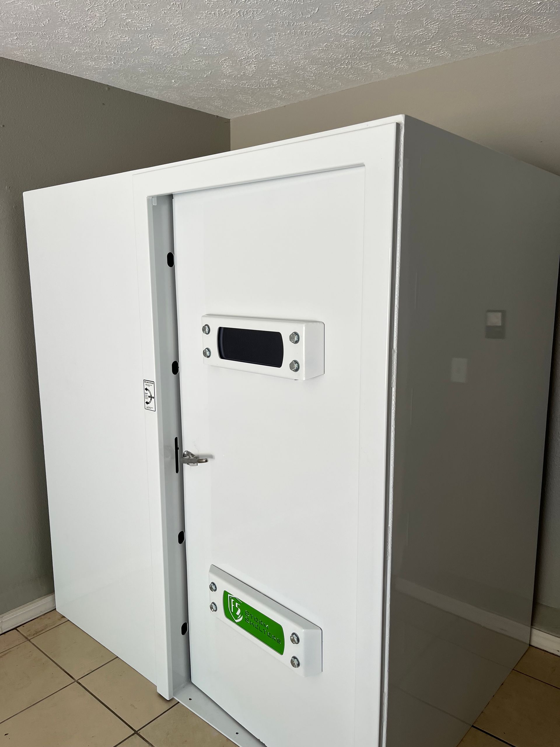 White walk-in freezer with heavy door and locking latches in a tiled room