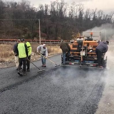 A group of people are working on a road.