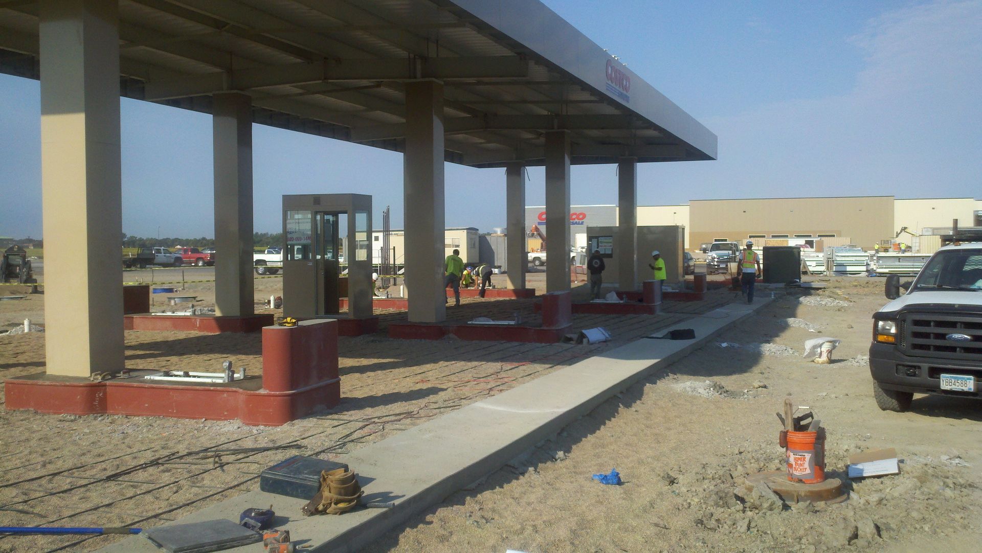 Construction site with partially built concrete structure and materials scattered on gravel