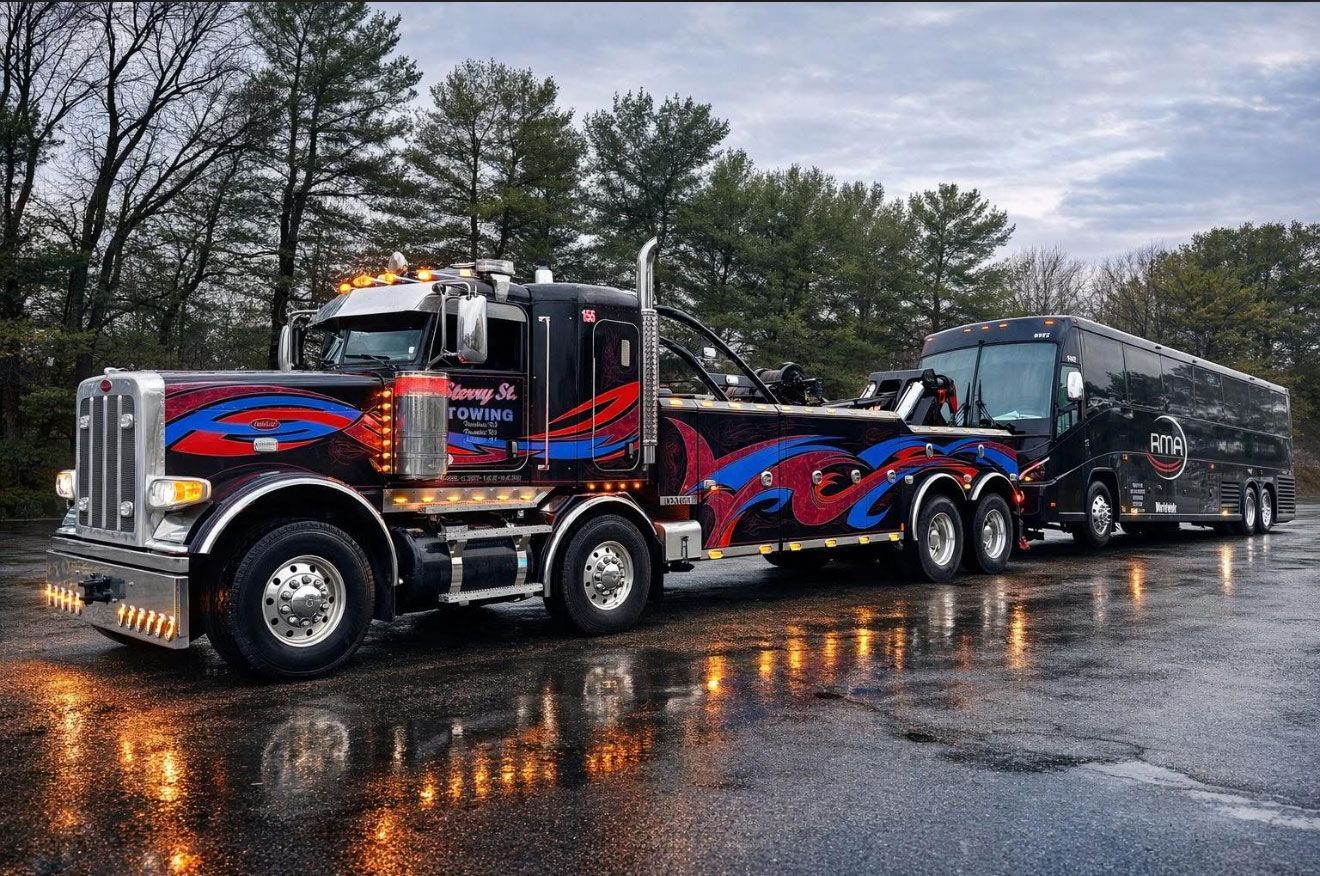 Colorful semi truck towing a black trailer on a wet road under cloudy skies.
