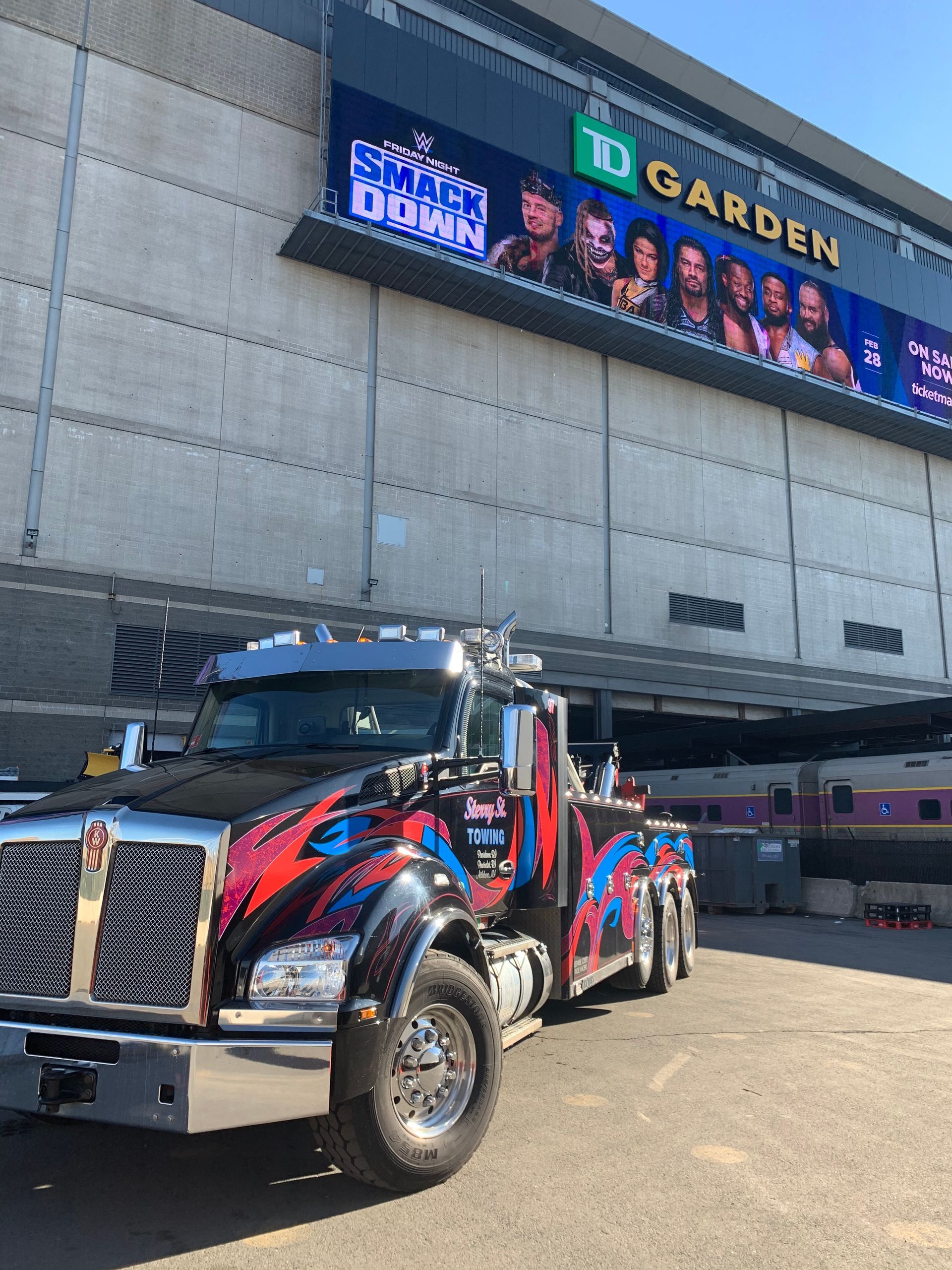 Custom black-and-red tow truck parked outside Madison Square Garden entrance.