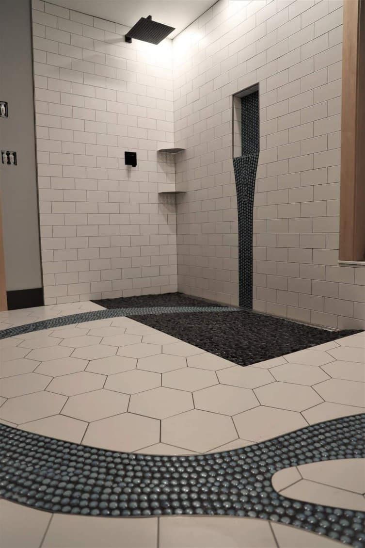 A bathroom with a walk in shower and a tiled floor