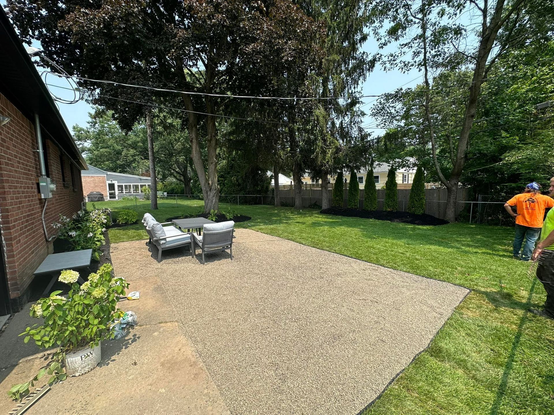A group of people are standing in a backyard.