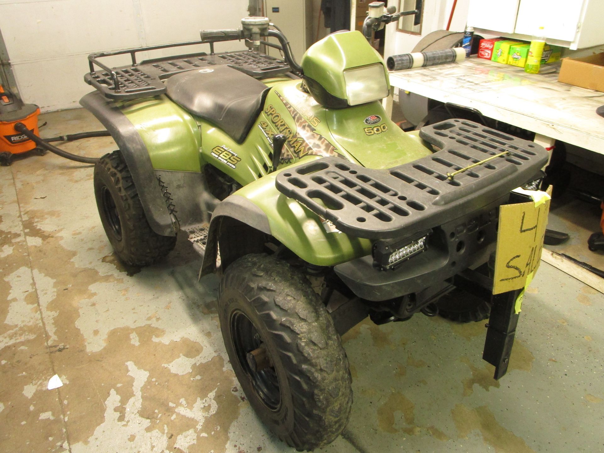 A green ATV with a yellow tag on it