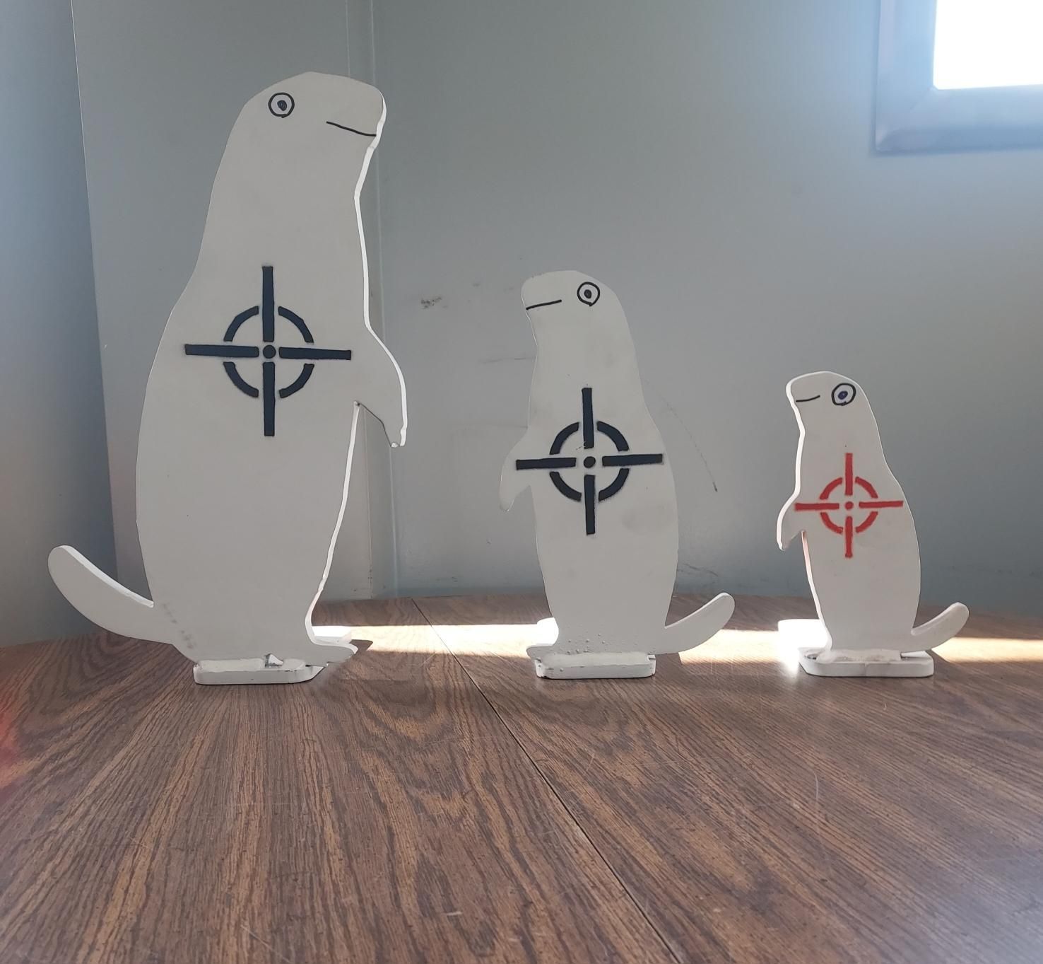 Three squirrels are sitting on a wooden table