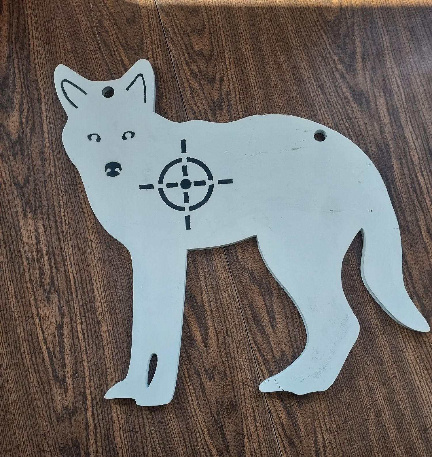 A white silhouette of a wolf with a target on its back
