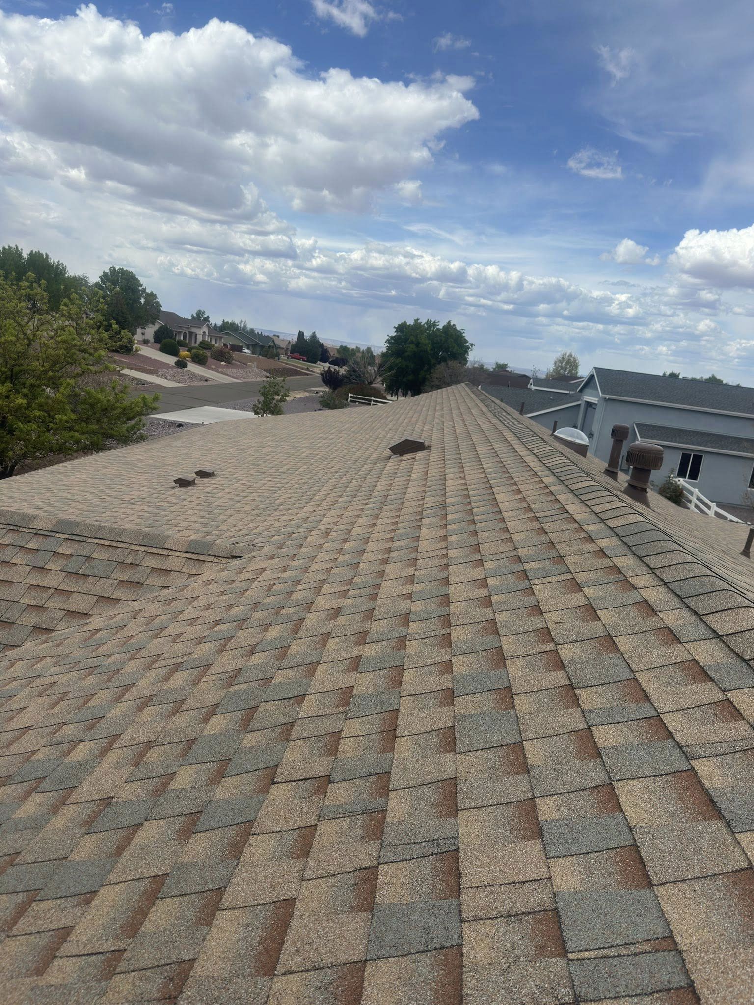 A roof with a lot of shingles on it and a blue sky in the background.