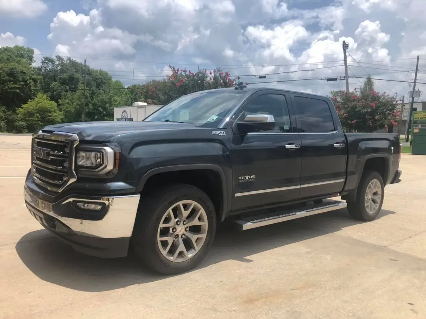 Dark gray GMC pickup truck parked outdoors on a sunny lot