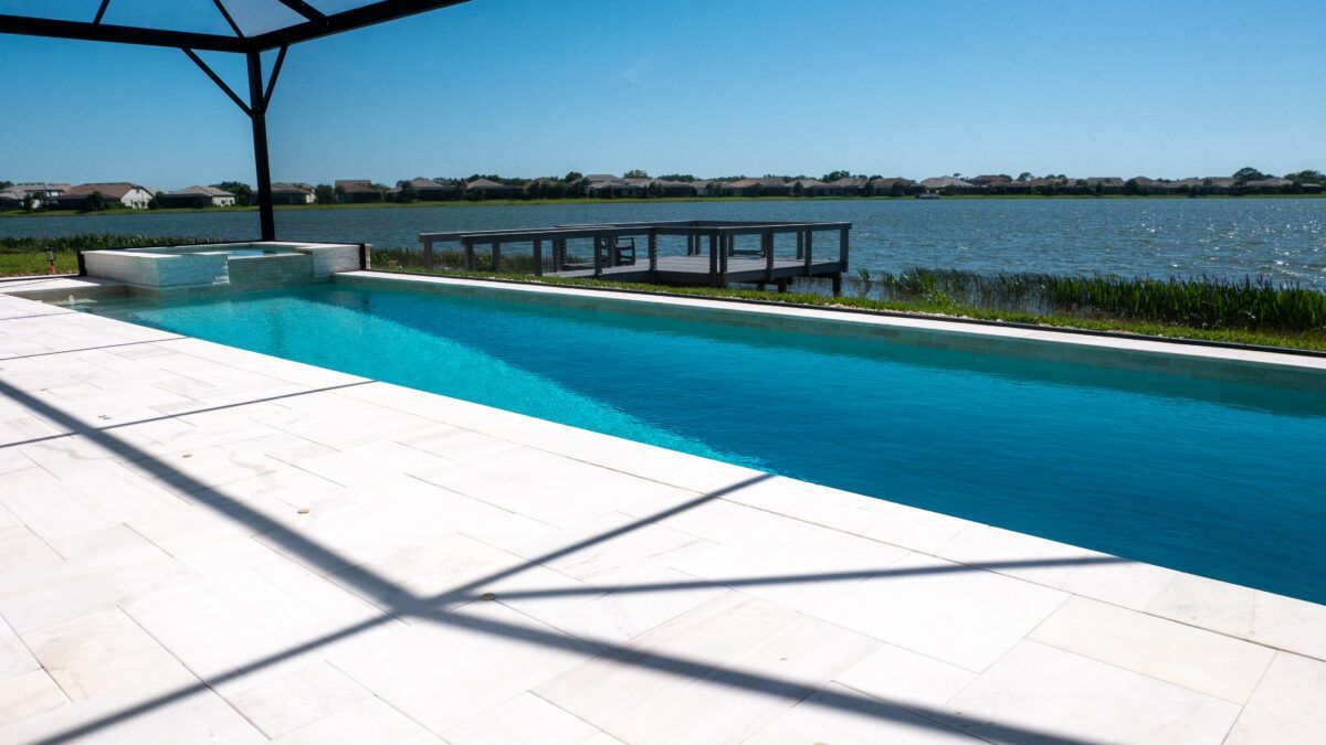 A large swimming pool with a view of a lake.