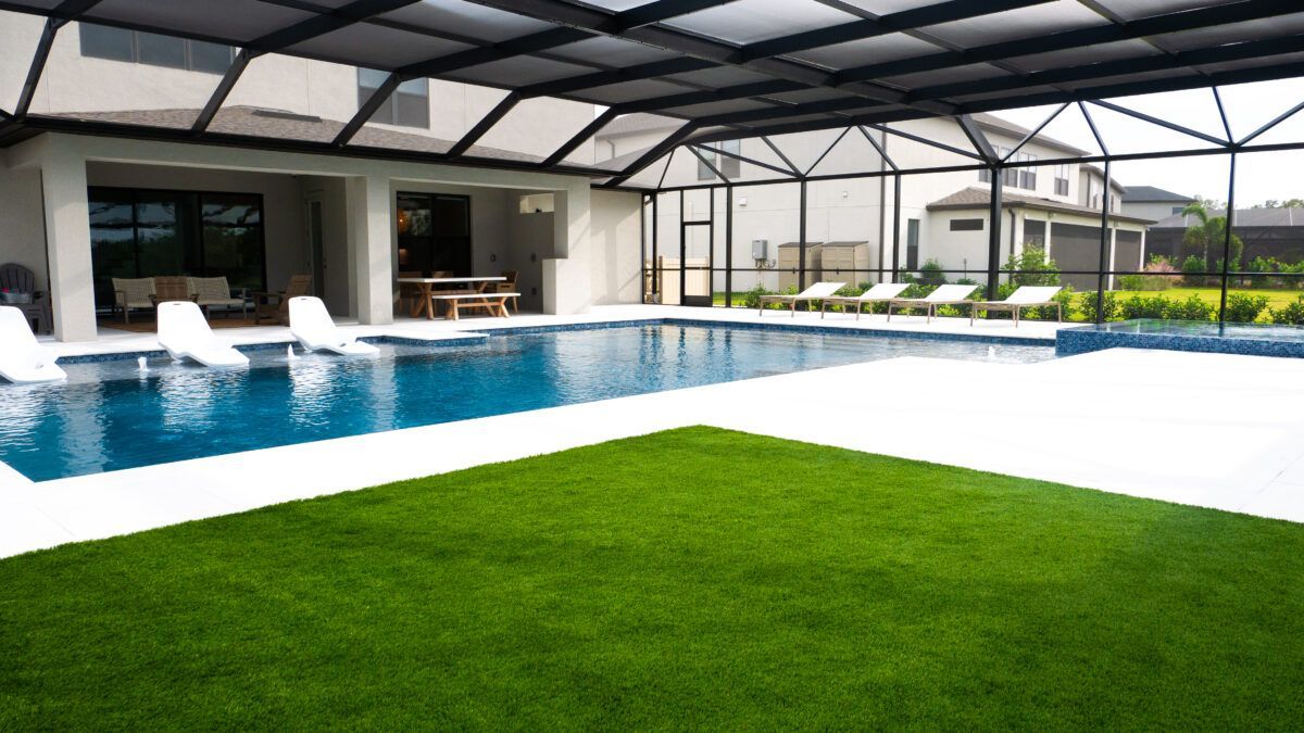 There is a large swimming pool in the backyard of a house.