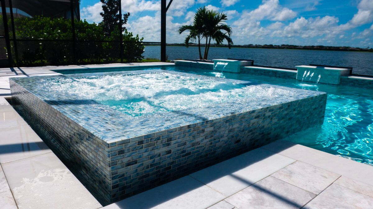 A large swimming pool with a hot tub in the middle of it.