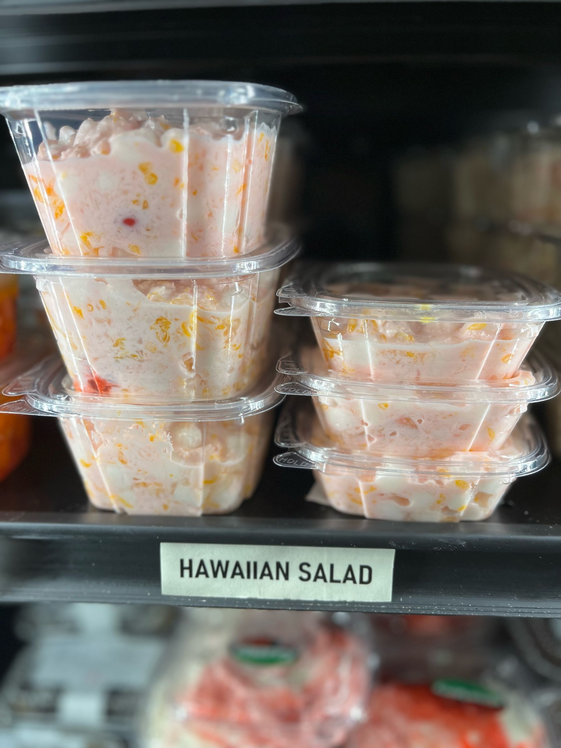 A hawaiian salad is stacked on top of each other on a shelf.