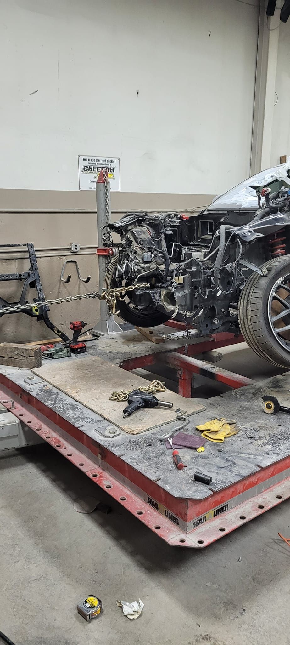 A motorcycle is sitting on top of a metal platform in a garage.