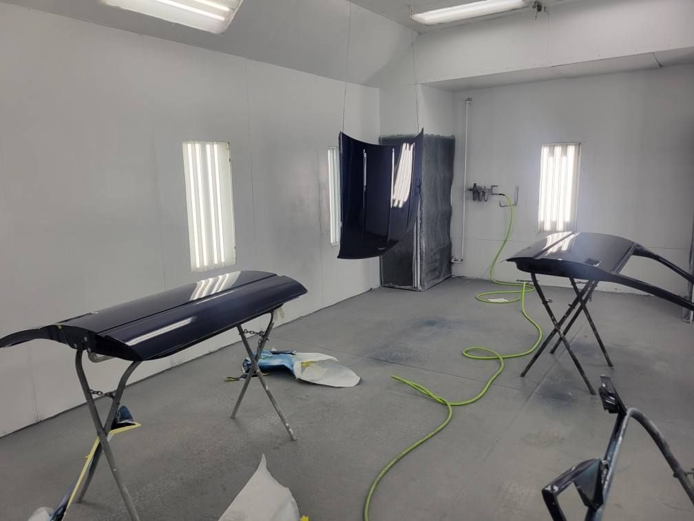 A paint booth with a hose hanging from the ceiling