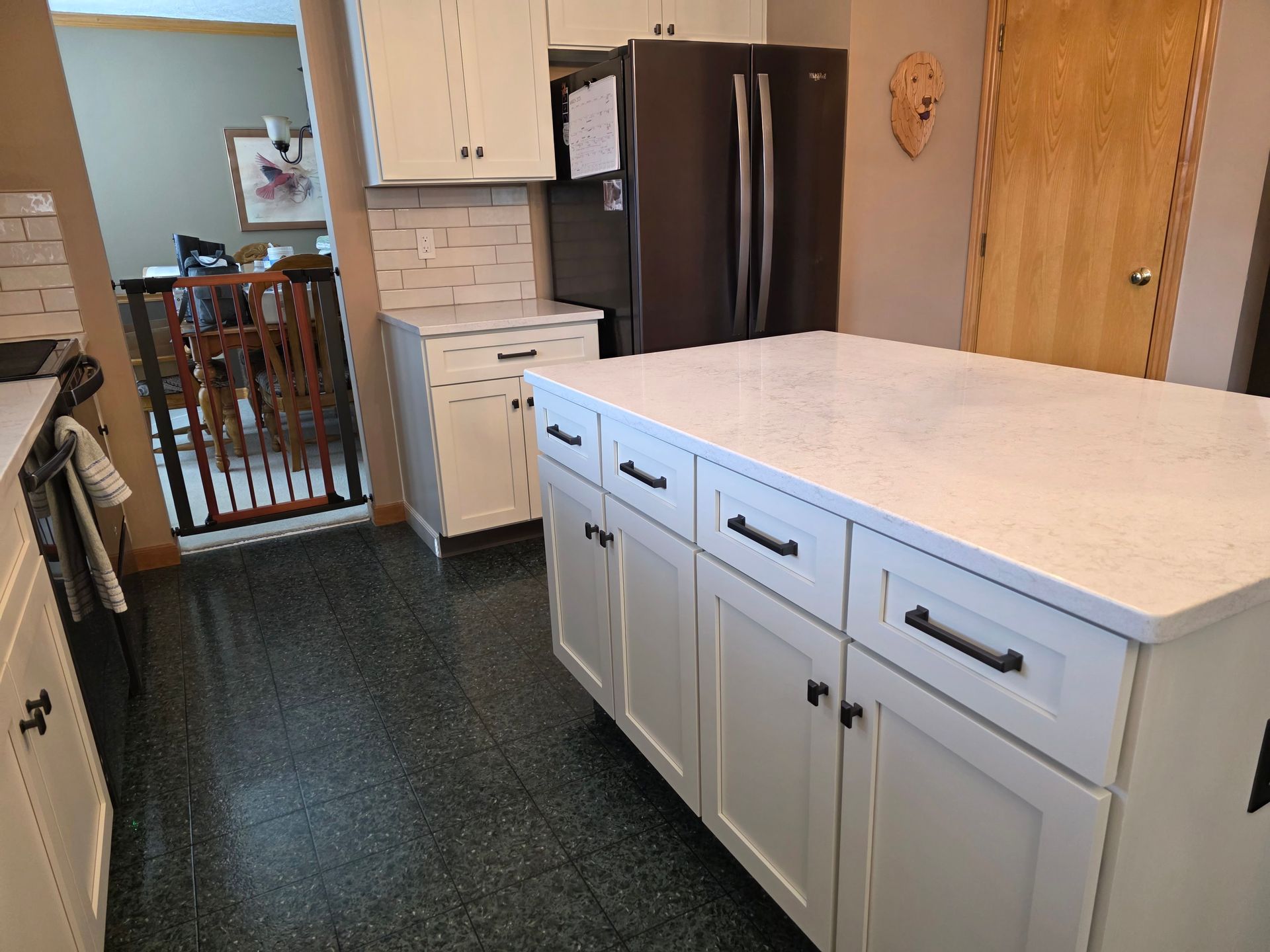 A kitchen with white cabinets and a large island in the middle.