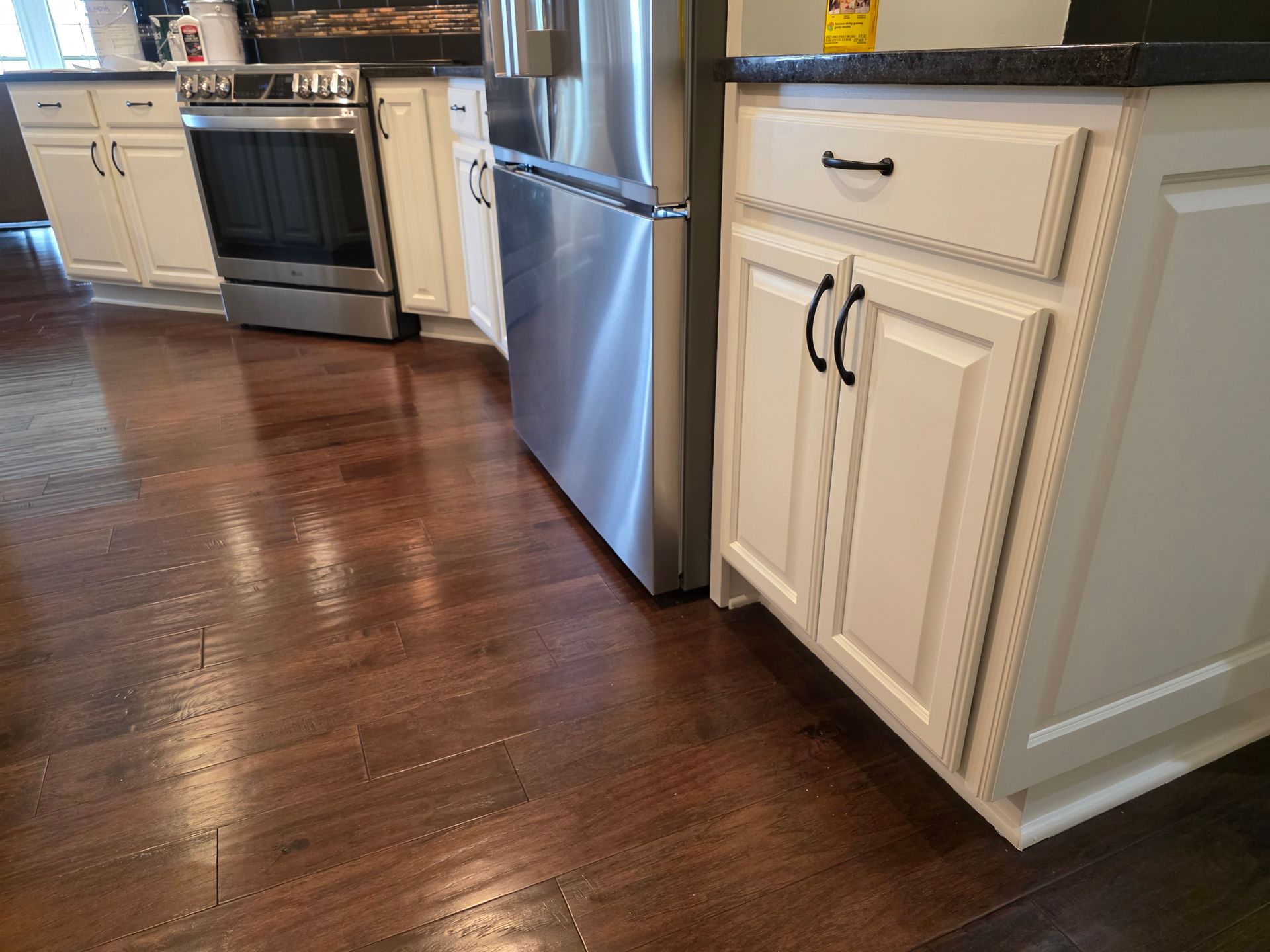 A kitchen with stainless steel appliances and white cabinets.