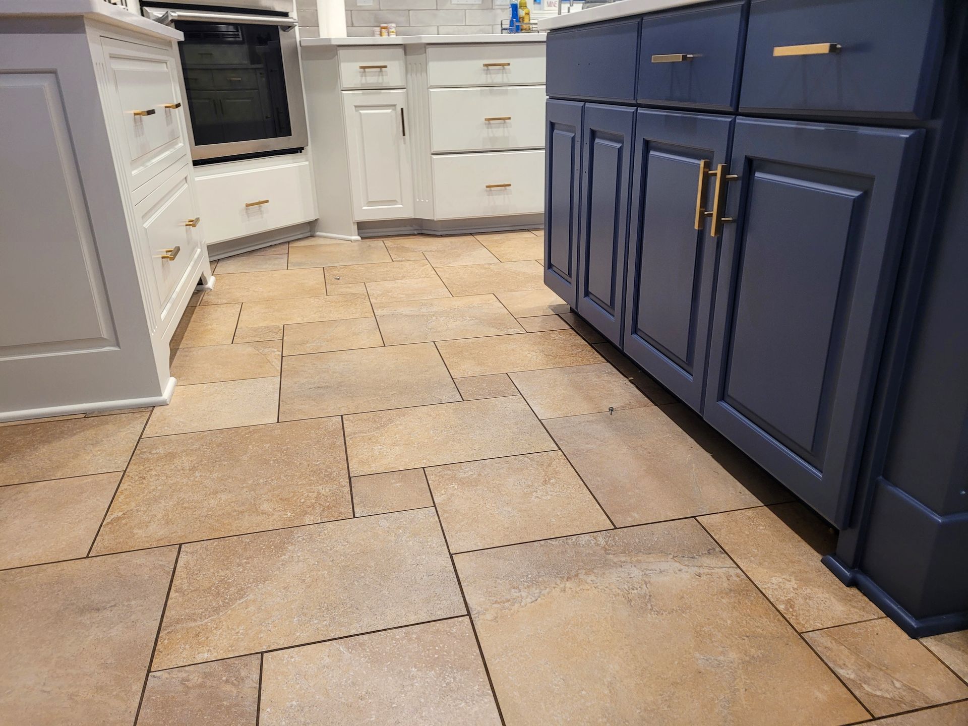 A kitchen with blue cabinets and a tile floor.